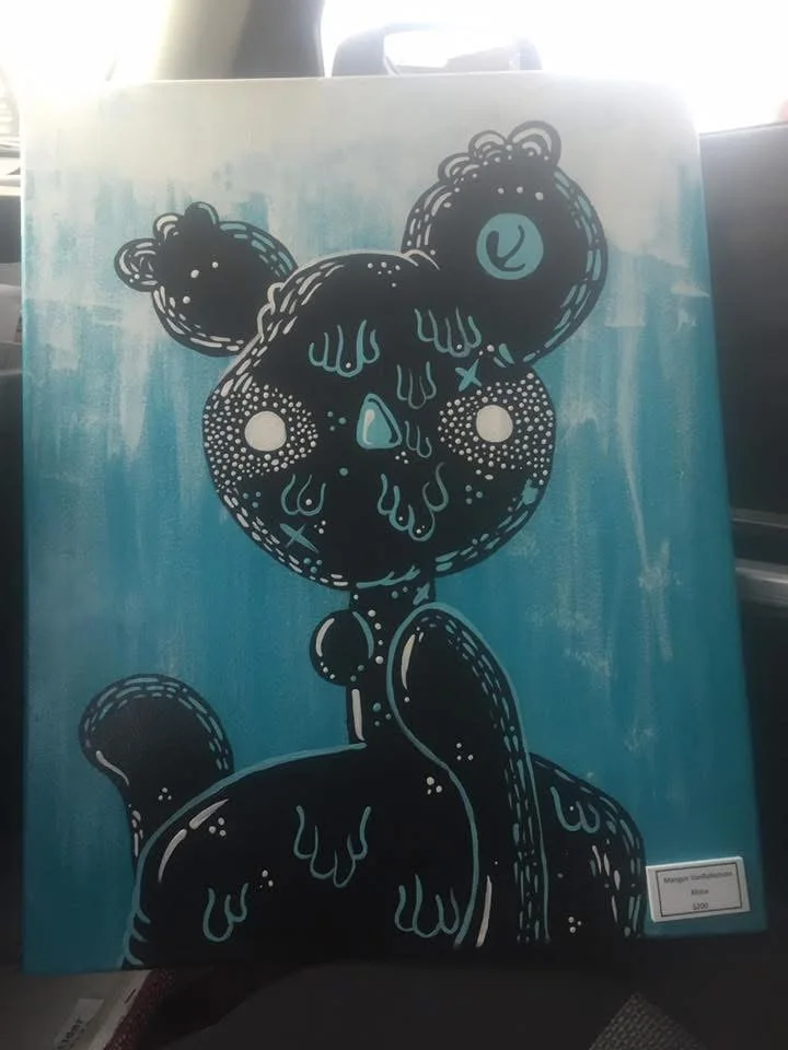 Original black bear-like painted figure against turquoise
